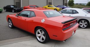 A 2008 Dodge Challenger SRT with other Dodge cars in a parking lot.